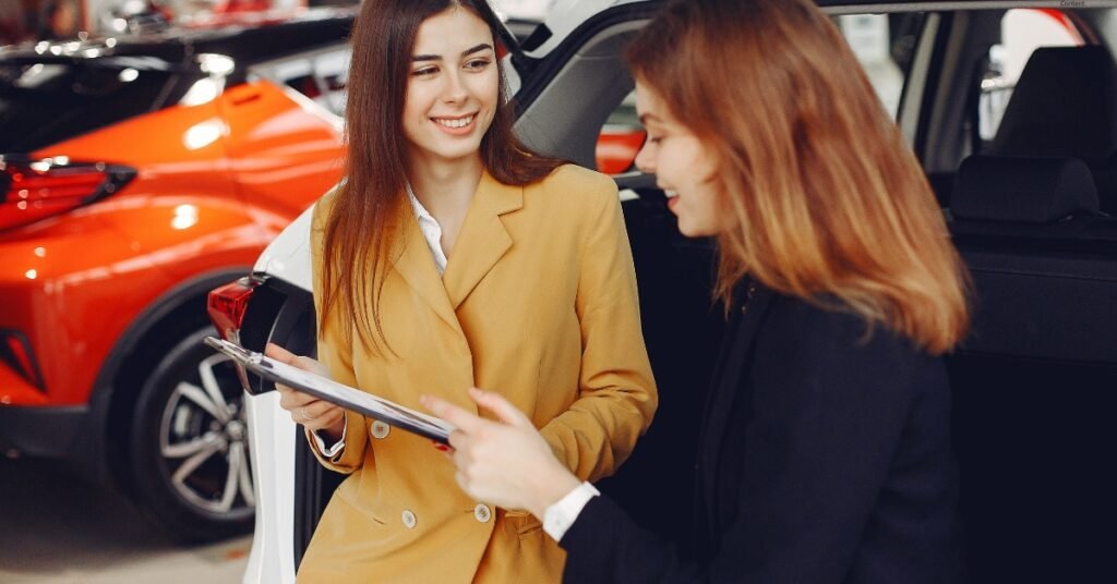 Car Dealer Discusses Market Trends while standing in car showroom